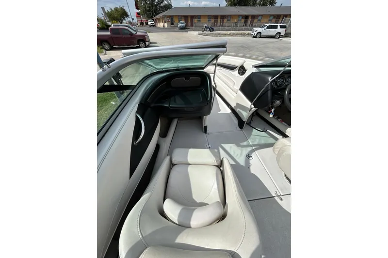 Slide: The Image of 2004 Crownline 202 BR boat interior with white seating and dashboard view. - 19