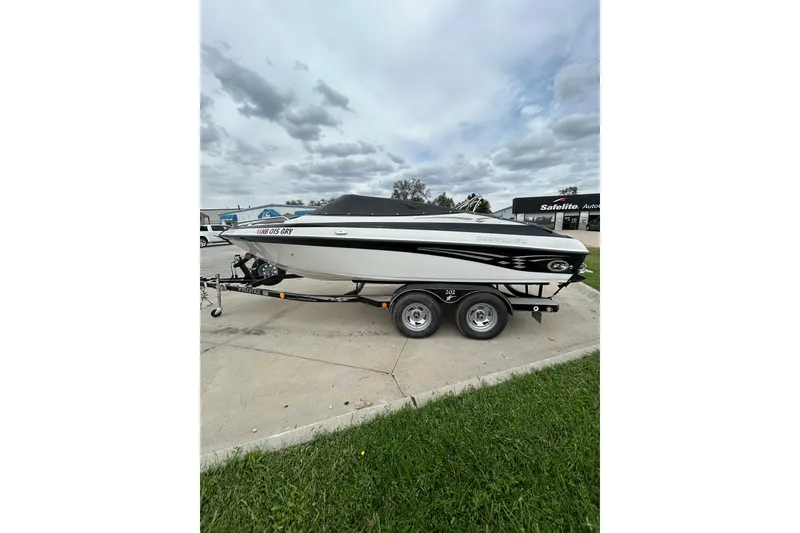 Slide: The Image of 2004 Crownline 202 BR boat on trailer, parked outdoors under cloudy sky. - 2