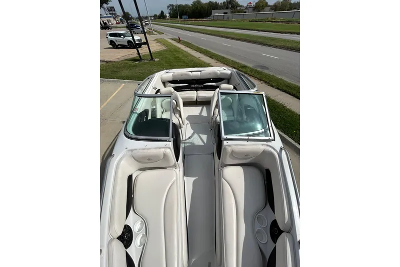 Slide: The Image of 2004 Crownline 202 BR boat with white interior, parked near a road. - 23