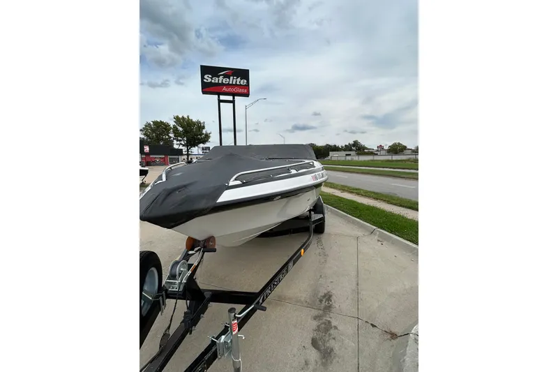 Slide: The Image of 2004 Crownline 202 BR boat on trailer, covered, parked near Safelite AutoGlass sign. - 4