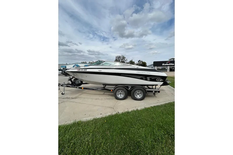Slide: The Image of 2004 Crownline 202 BR boat on trailer, parked outdoors under cloudy sky. - 6