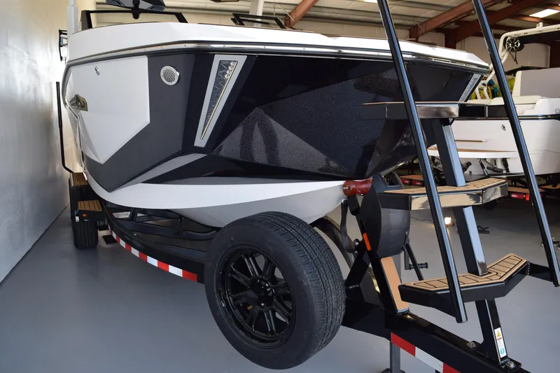 Slide: The Image of 2026 Nautique Super Air Nautique G25 Paragon boat on trailer in showroom. - 2