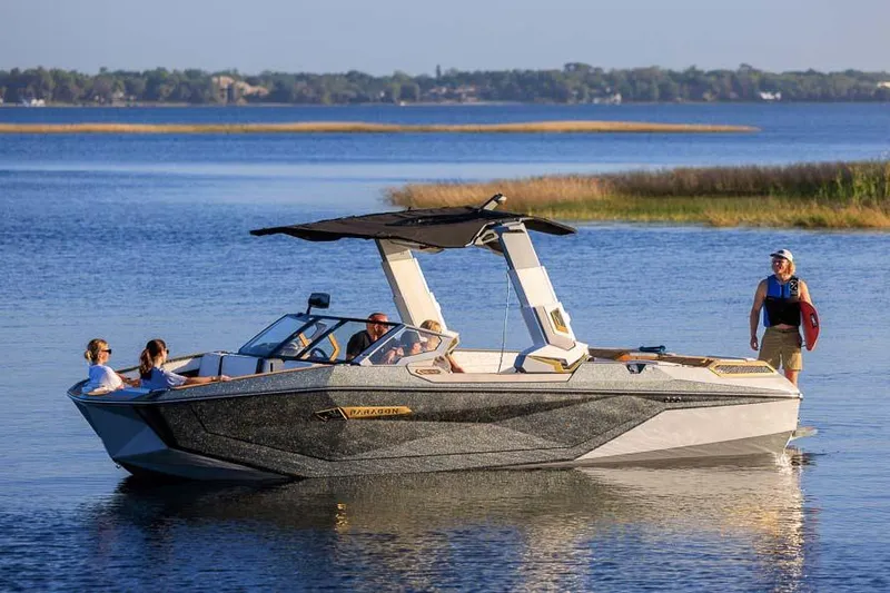 Slide: The Image of Manufacturer Provided Image: 2026 Nautique Super Air Nautique G25 Paragon on a serene lake with passengers. - 21