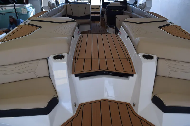 Slide: The Image of 2026 Nautique Super Air Nautique G25 Paragon interior with tan seating and teak flooring. - 6