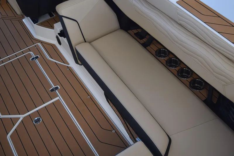Slide: The Image of 2026 Nautique Super Air Nautique G25 Paragon interior with beige seating and cup holders. - 9
