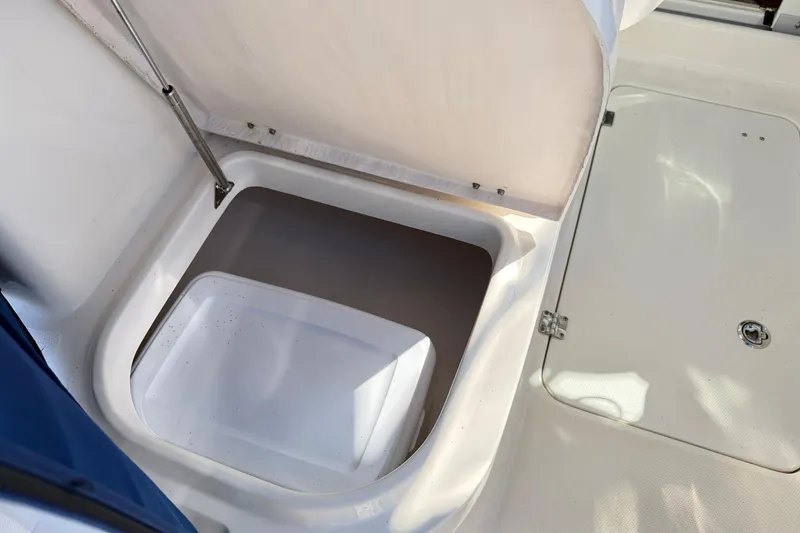 Slide: The Image of 2014 Robalo R245 Walkaround storage compartment with open hatch, showcasing interior space. - 13