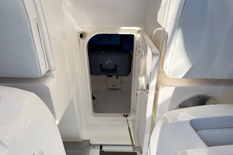 Slide: The Image of 2014 Robalo R245 Walkaround boat storage compartment with open hatch and visible equipment. - 16