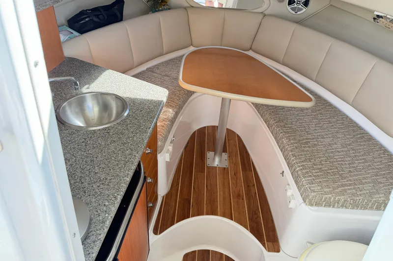 Slide: The Image of 2014 Robalo R245 Walkaround cabin interior with kitchenette, sink, and seating area. - 23