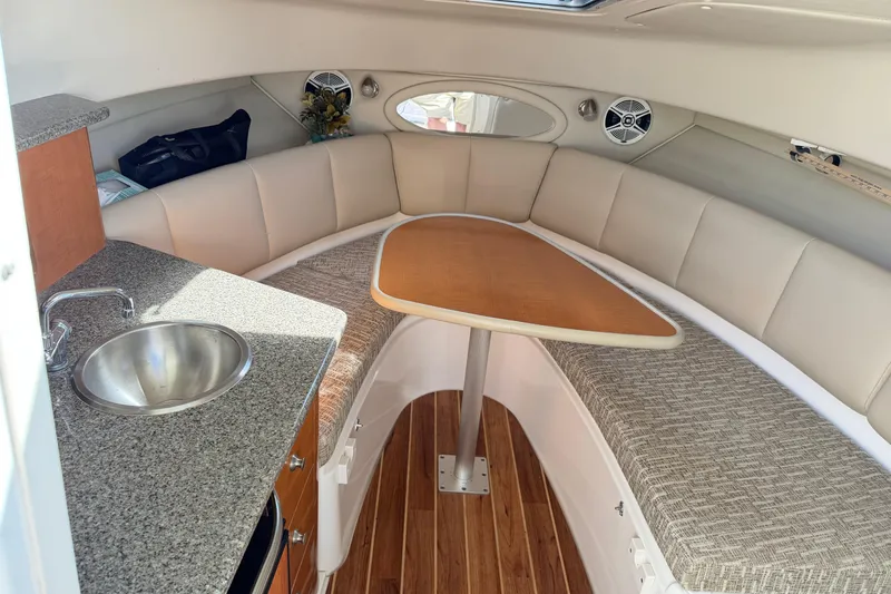 Slide: The Image of 2014 Robalo R245 Walkaround cabin interior with seating, table, and sink. - 24