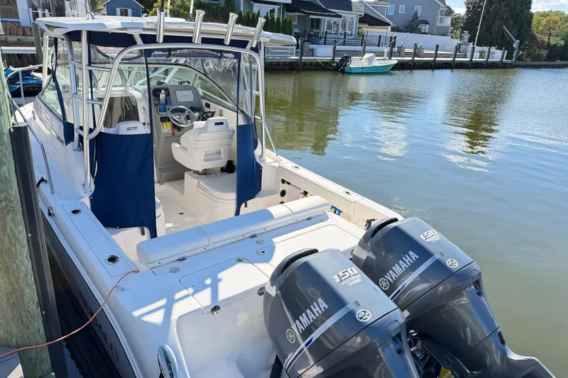 Slide: The Image of 2014 Robalo R245 Walkaround boat with Yamaha engines docked by waterfront homes. - 3
