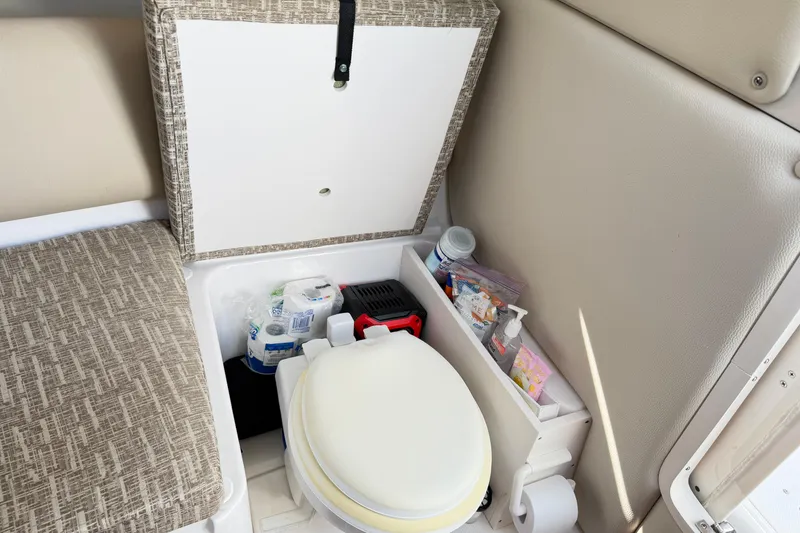 Slide: The Image of 2014 Robalo R245 Walkaround boat interior with compact toilet and storage. - 31