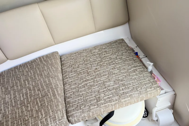 Slide: The Image of 2014 Robalo R245 Walkaround cabin interior with cushioned seating and storage area. - 34