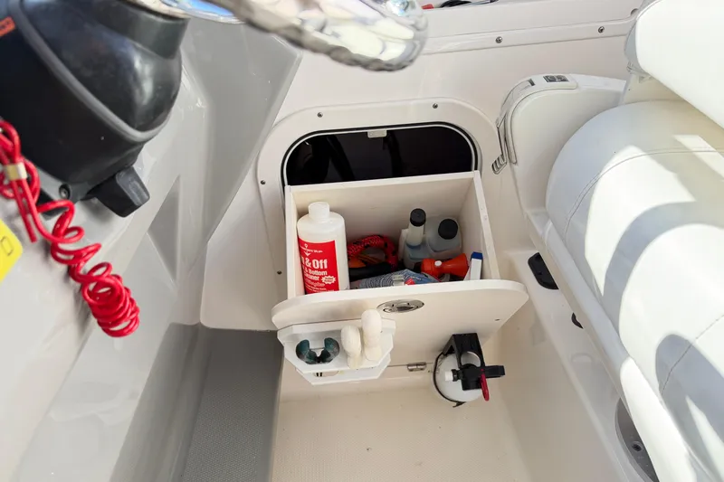 Slide: The Image of 2014 Robalo R245 Walkaround boat storage compartment with cleaning supplies and accessories. - 36