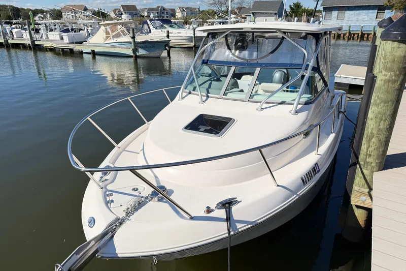 Slide: The Image of 2014 Robalo R245 Walkaround boat docked in a marina, featuring sleek design and spacious deck. - 4