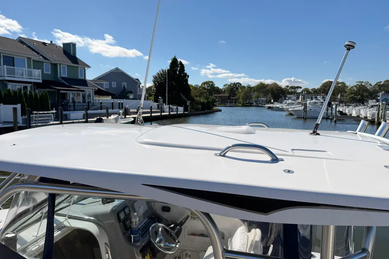 Slide: The Image of 2014 Robalo R245 Walkaround boat docked near waterfront homes and marina. - 40