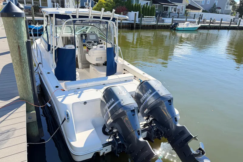 Slide: The Image of 2014 Robalo R245 Walkaround boat docked with twin Yamaha engines. - 46