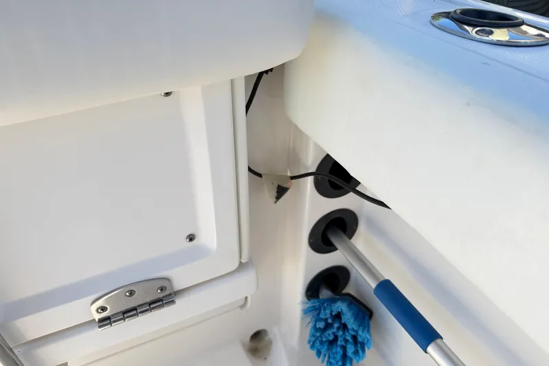 Slide: The Image of 2014 Robalo R245 Walkaround boat interior with storage compartment and cleaning brush. - 47