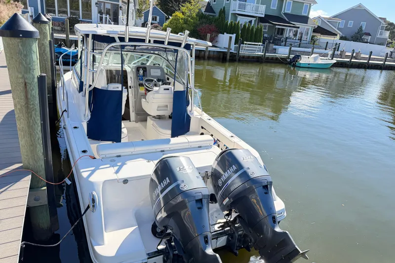 Slide: The Image of 2014 Robalo R245 Walkaround boat docked with twin Yamaha engines. - 48