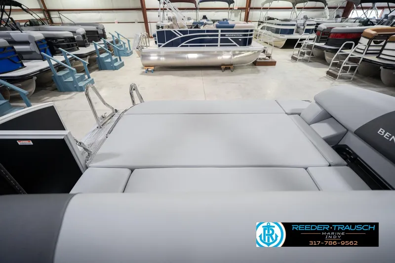 Slide: The Image of 2026 Bennington 20 SSB pontoon boat interior in showroom, featuring sleek seating and modern design. - 18