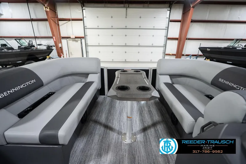 Slide: The Image of 2026 Bennington 20 SSB pontoon boat interior with gray seating and table in showroom. - 21