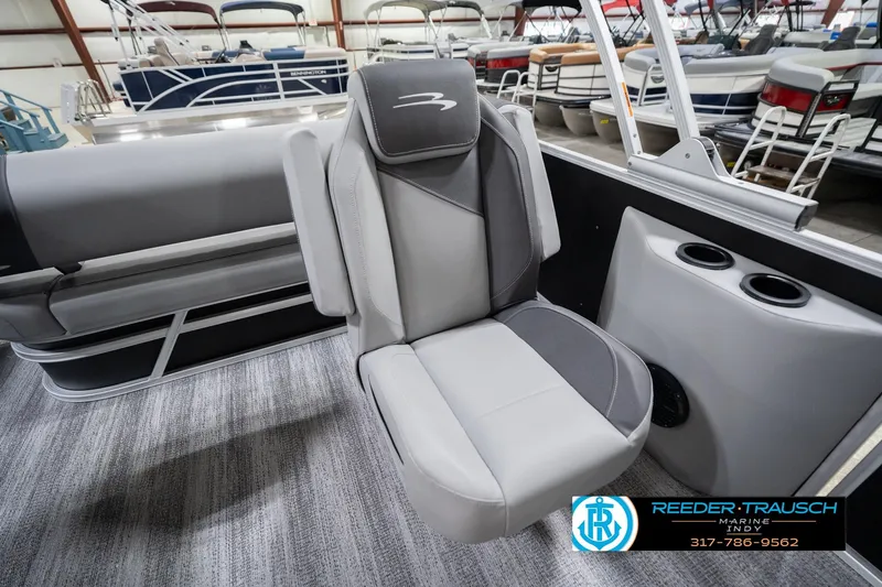 Slide: The Image of 2026 Bennington 20 SSB boat interior with gray seating and cup holders in showroom. - 25