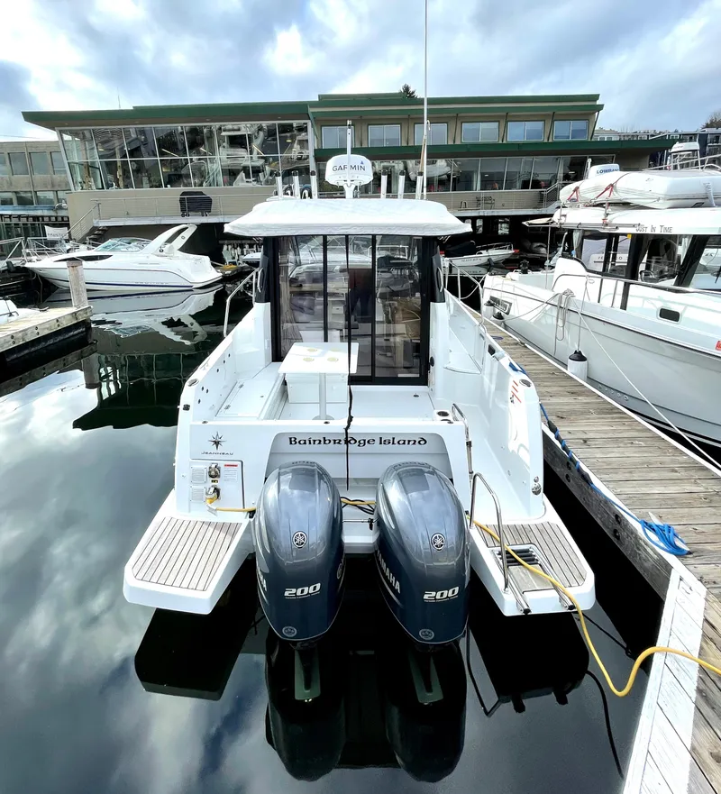 Slide: The Image of 2019 Jeanneau NC 895 boat docked, featuring twin engines, in a marina setting. - 1