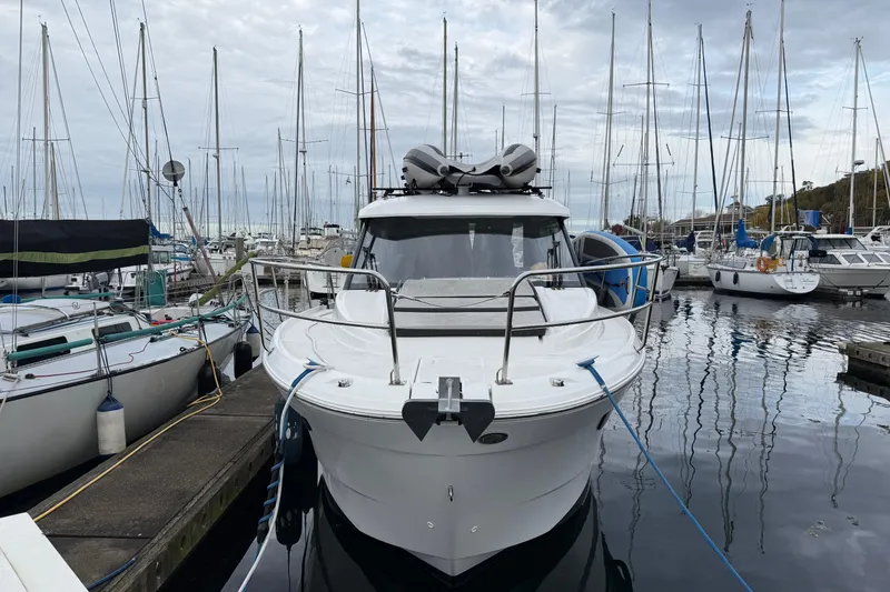 Slide: The Image of 2019 Jeanneau NC 895 docked at a marina, surrounded by sailboats. - 21