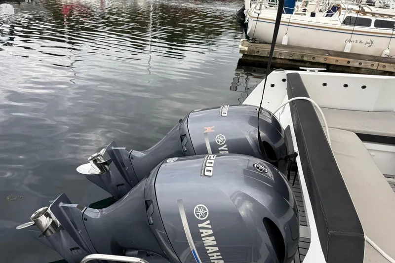 Slide: The Image of Twin Yamaha 200 outboard engines on a 2019 Jeanneau NC 895 boat at a marina. - 23