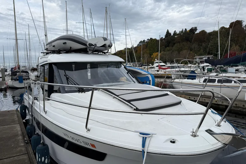 Slide: The Image of 2019 Jeanneau NC 895 docked at a marina with sailboats in the background. - 25