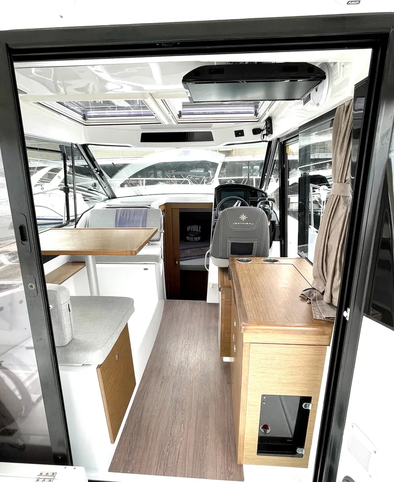 Slide: The Image of 2019 Jeanneau NC 895 interior with modern design, featuring seating and helm station. - 3