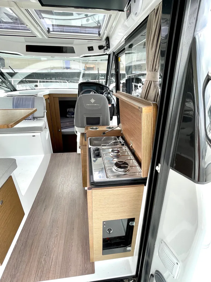 Slide: The Image of Interior of 2019 Jeanneau NC 895 boat with modern kitchen and steering area. - 4