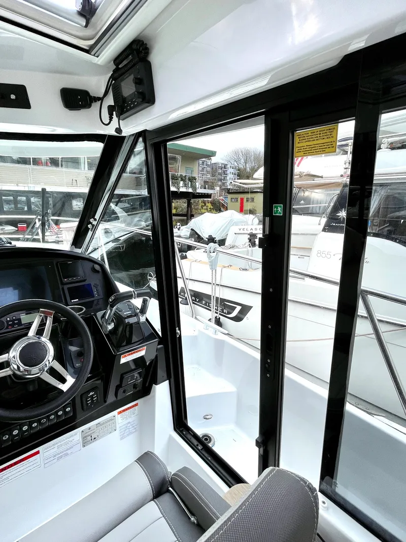 Slide: The Image of Interior view of a 2019 Jeanneau NC 895 boat cockpit with steering wheel and controls. - 6
