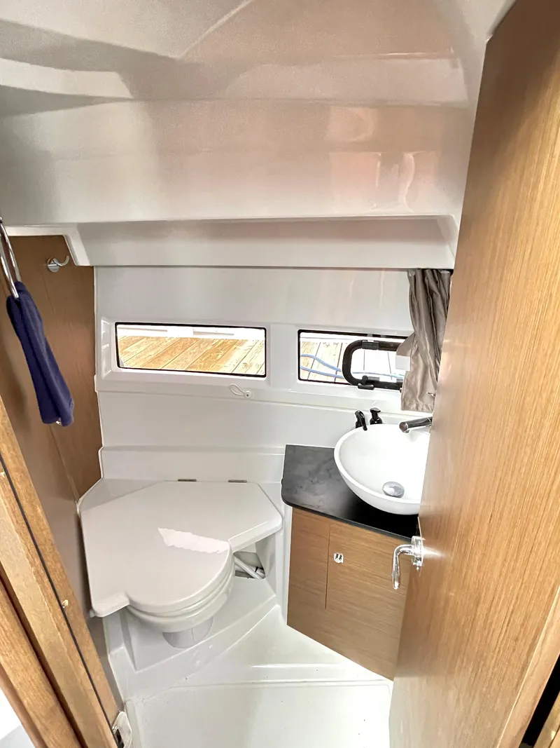 Slide: The Image of 2019 Jeanneau NC 895 boat bathroom with toilet, sink, and window. - 8
