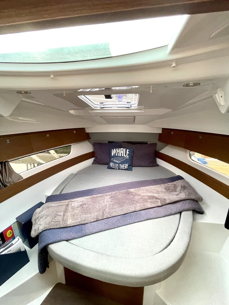 Slide: The Image of 2019 Jeanneau NC 895 cabin interior with skylight, cozy bed, and nautical decor. - 9