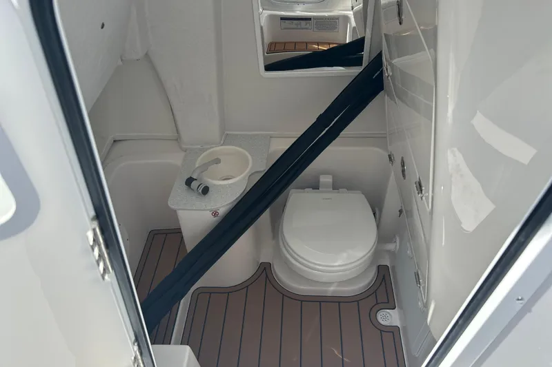 Slide: The Image of 2026 Sea Fox 268 Commander boat bathroom with toilet and sink, featuring wood-style flooring. - 15