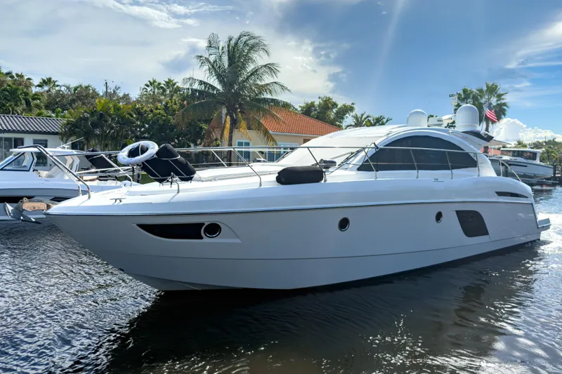 Slide: The Image of 2015 Beneteau Gran Turismo 49 yacht docked, surrounded by palm trees and clear skies. - 0