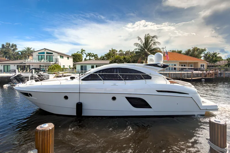 Slide: The Image of 2015 Beneteau Gran Turismo 49 yacht docked in a scenic waterfront setting. - 1