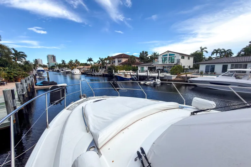 Slide: The Image of 2015 Beneteau Gran Turismo 49 yacht docked in a scenic canal with waterfront homes. - 14