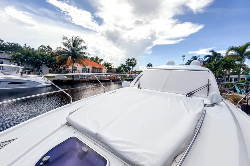 Slide: The Image of 2015 Beneteau Gran Turismo 49 yacht docked by palm trees and waterfront homes. - 15