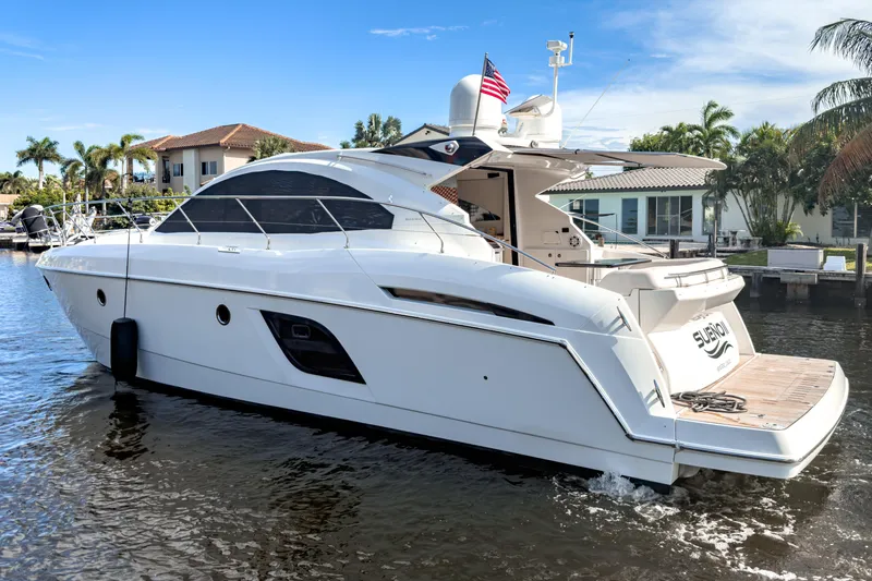 Slide: The Image of 2015 Beneteau Gran Turismo 49 yacht cruising on a sunny day near waterfront homes. - 2