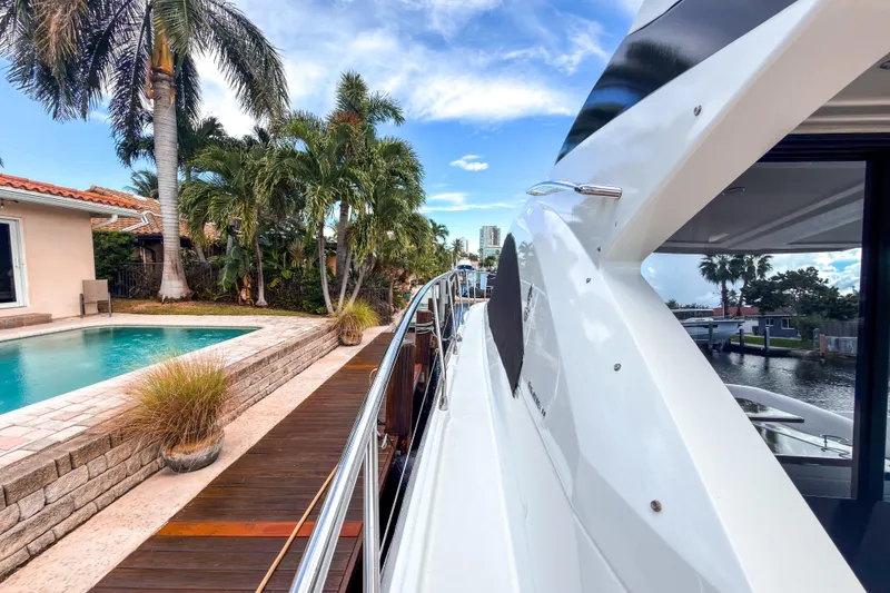 Slide: The Image of 2015 Beneteau Gran Turismo 49 yacht docked near a poolside with palm trees. - 37
