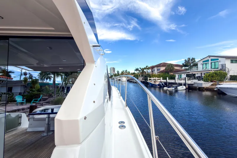 Slide: The Image of 2015 Beneteau Gran Turismo 49 yacht docked by waterfront homes under blue sky. - 38