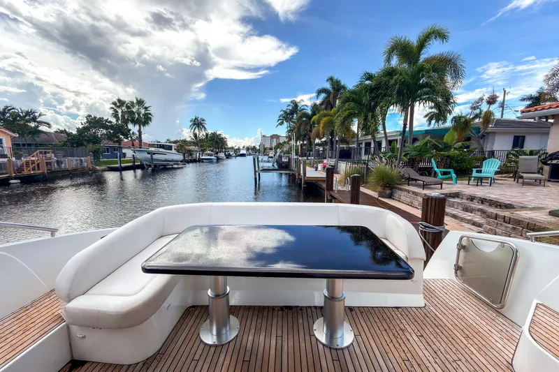 Slide: The Image of Beneteau Gran Turismo 49 yacht deck with waterfront view, palm trees, and clear sky. - 4
