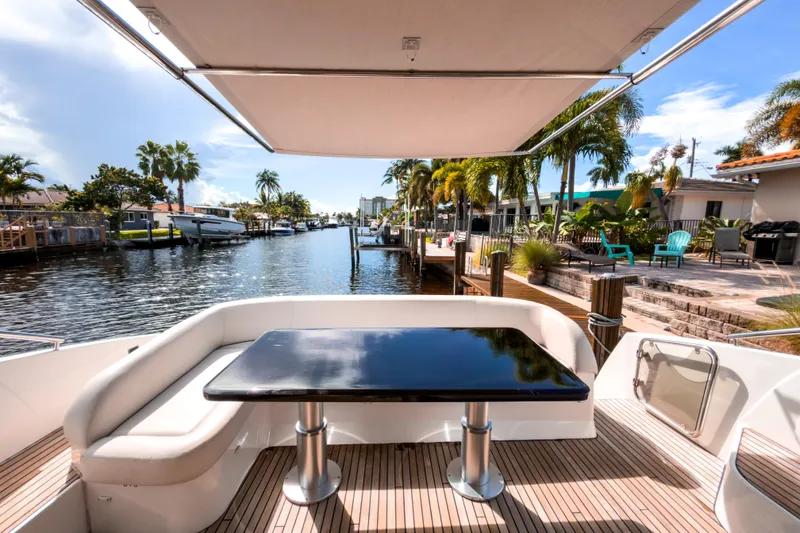 Slide: The Image of 2015 Beneteau Gran Turismo 49 yacht deck with seating, table, and waterfront view. - 5