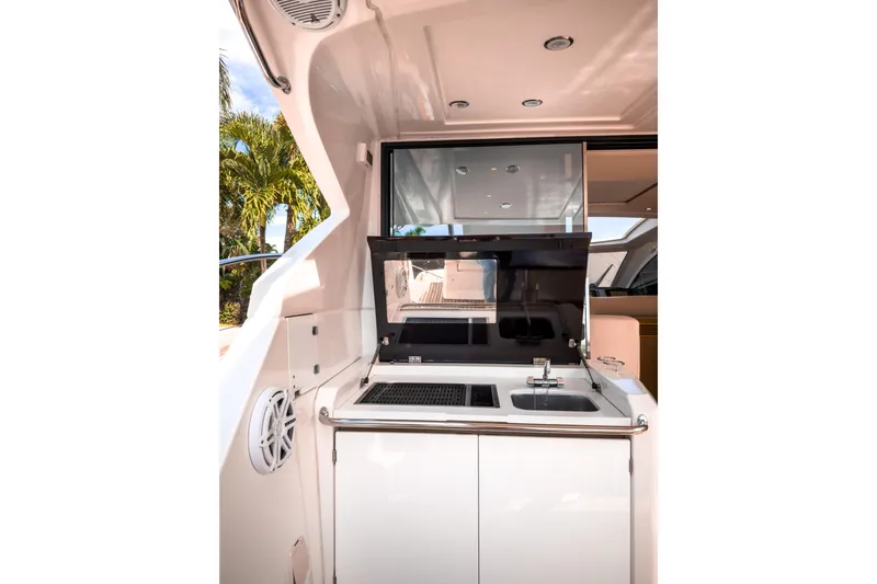 Slide: The Image of Outdoor kitchenette on a 2015 Beneteau Gran Turismo 49 yacht, featuring a sink and grill. - 8