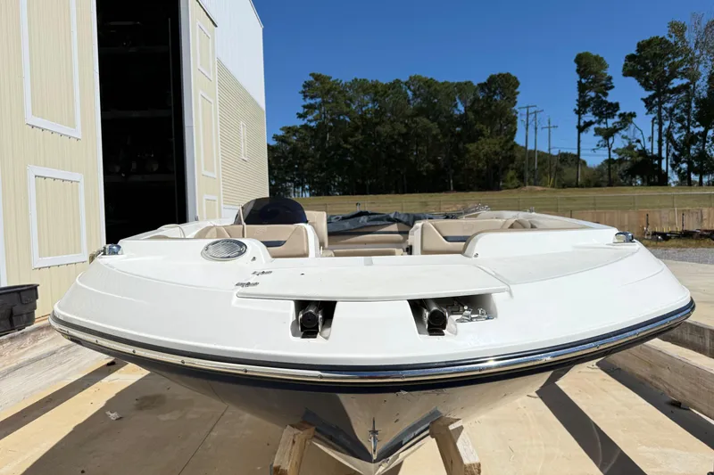 Slide: The Image of 2021 Hurricane SunDeck Sport 205 IO boat docked outdoors, front view. - 2