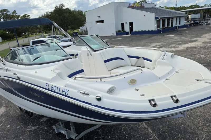 Slide: The Image of 2012 Hurricane SunDeck 2000 OB boat with blue accents, parked at Royal Palm Boat Sales. - 23
