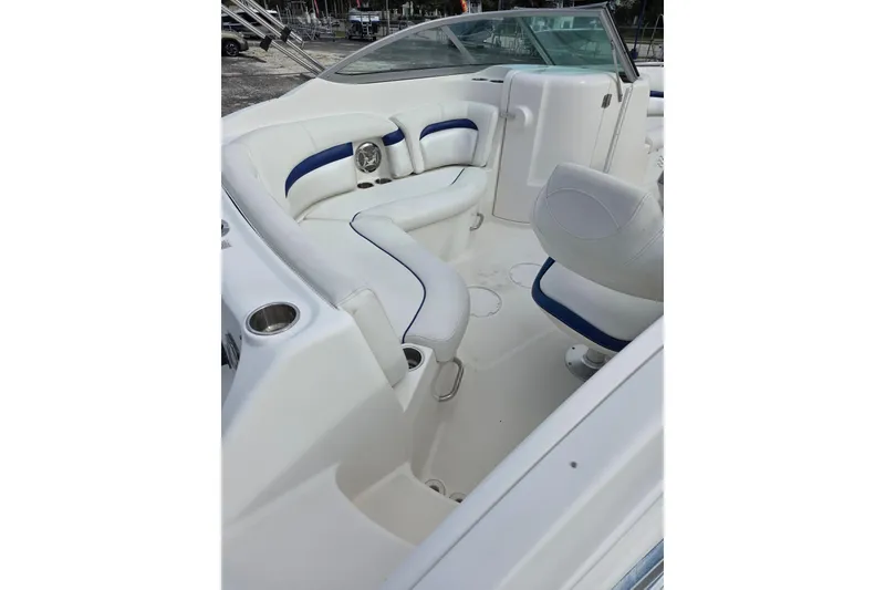 Slide: The Image of 2012 Hurricane SunDeck 2000 OB interior with white and blue seating, cup holders, and steering area. - 8