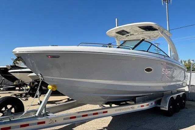 Slide: The Image of 2024 Chaparral 30 Surf boat on trailer, sleek design, sunny day. - 16