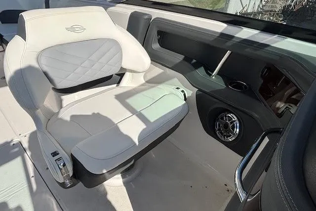 Slide: The Image of 2024 Chaparral 30 Surf boat cockpit with white captain's chair and steering wheel. - 35